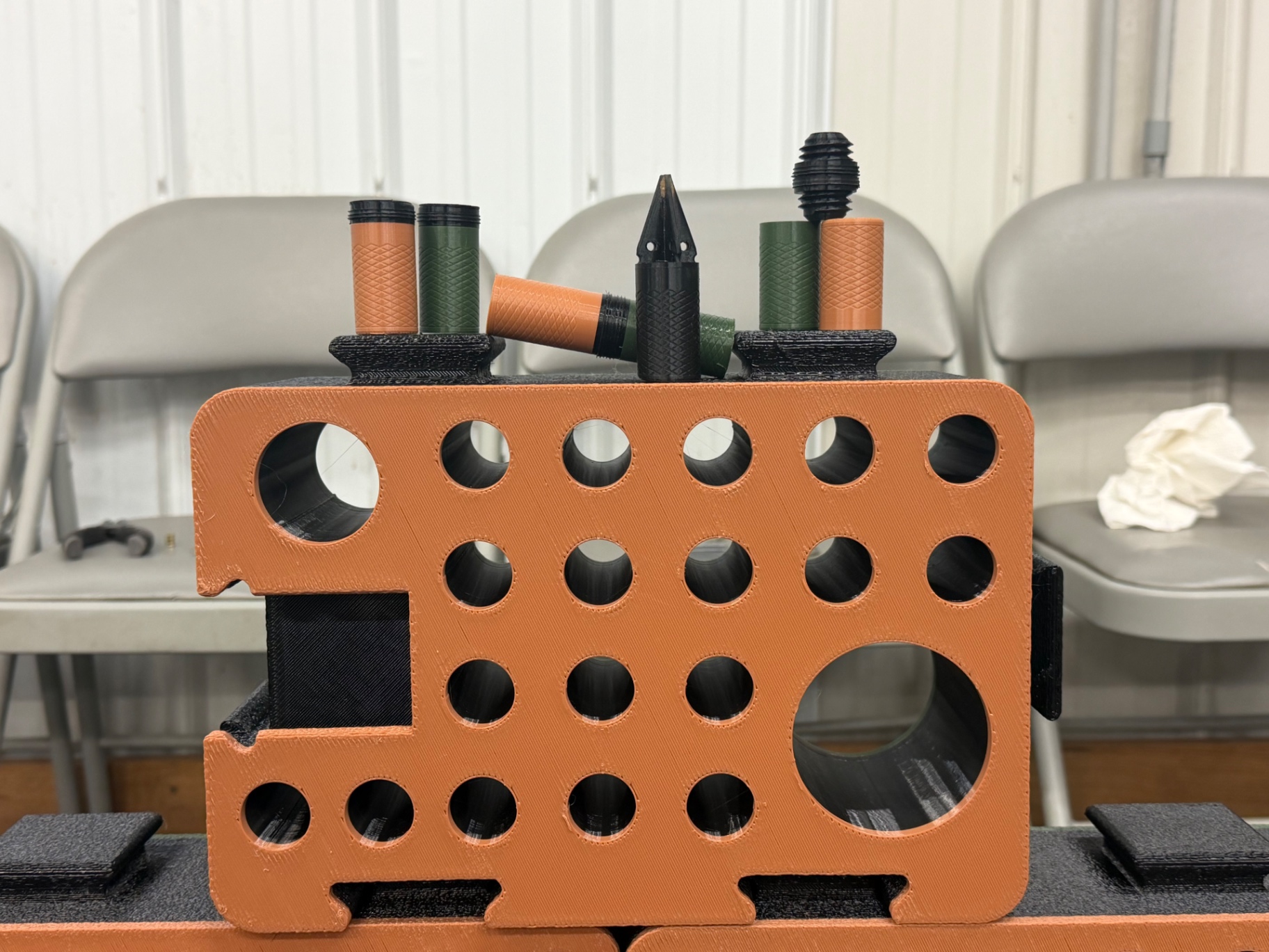 Close-up of an orange D-Block face with orange, green and black scent tubes resting on top