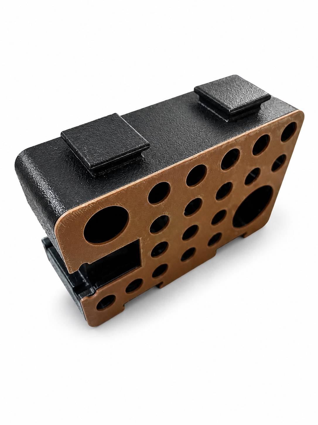 Single orange and black D-Block viewed from above at an angle, showing the black top studs and orange perforated face