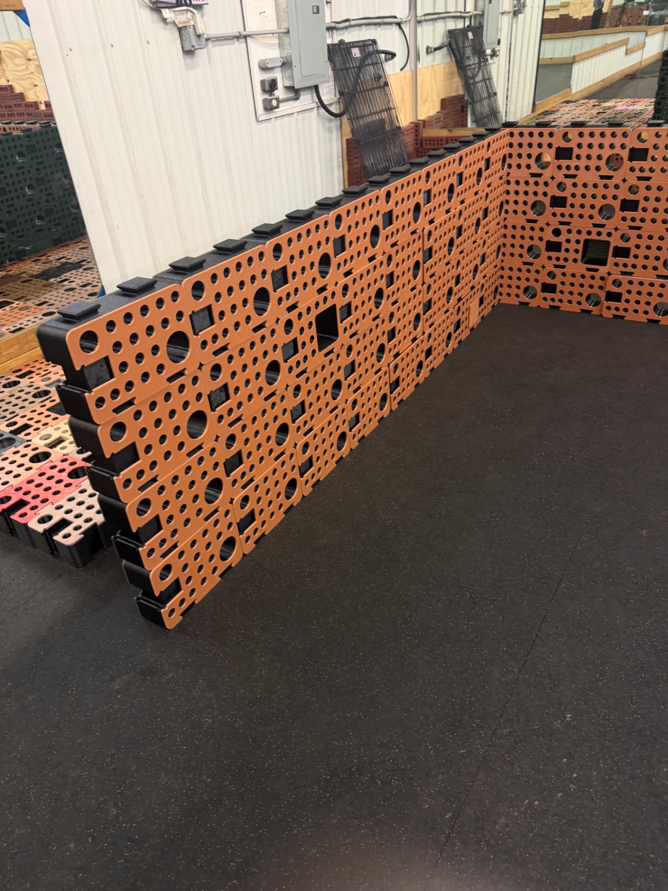 A multi-course wall of orange and black D-Blocks assembled in a training facility, forming a corner search problem
