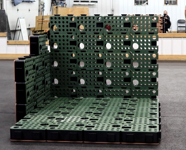 Green and black D-Blocks built into a room corner with two walls and a floor